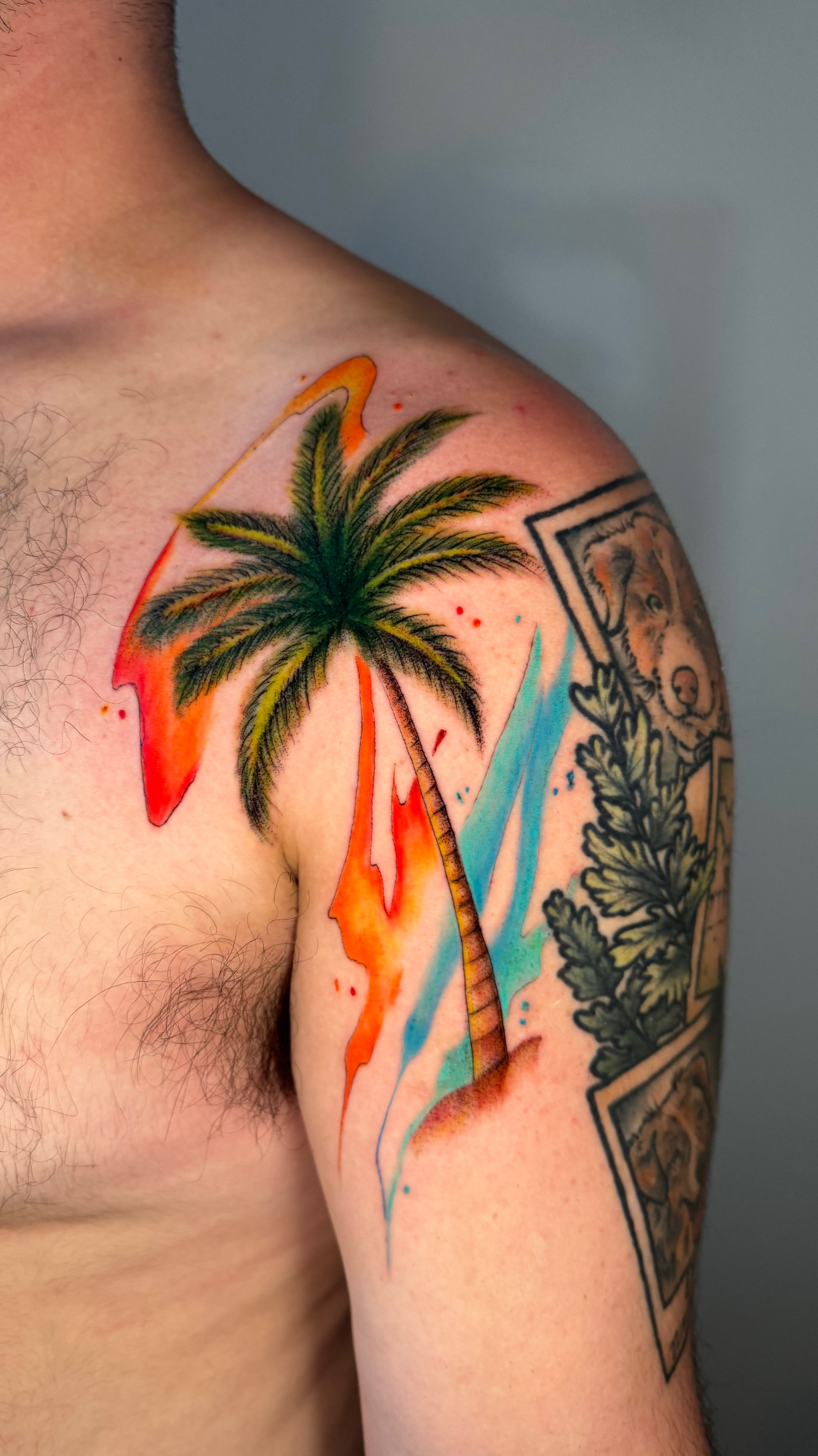 Colorful palm tree with orange and blue watercolor background tattoo